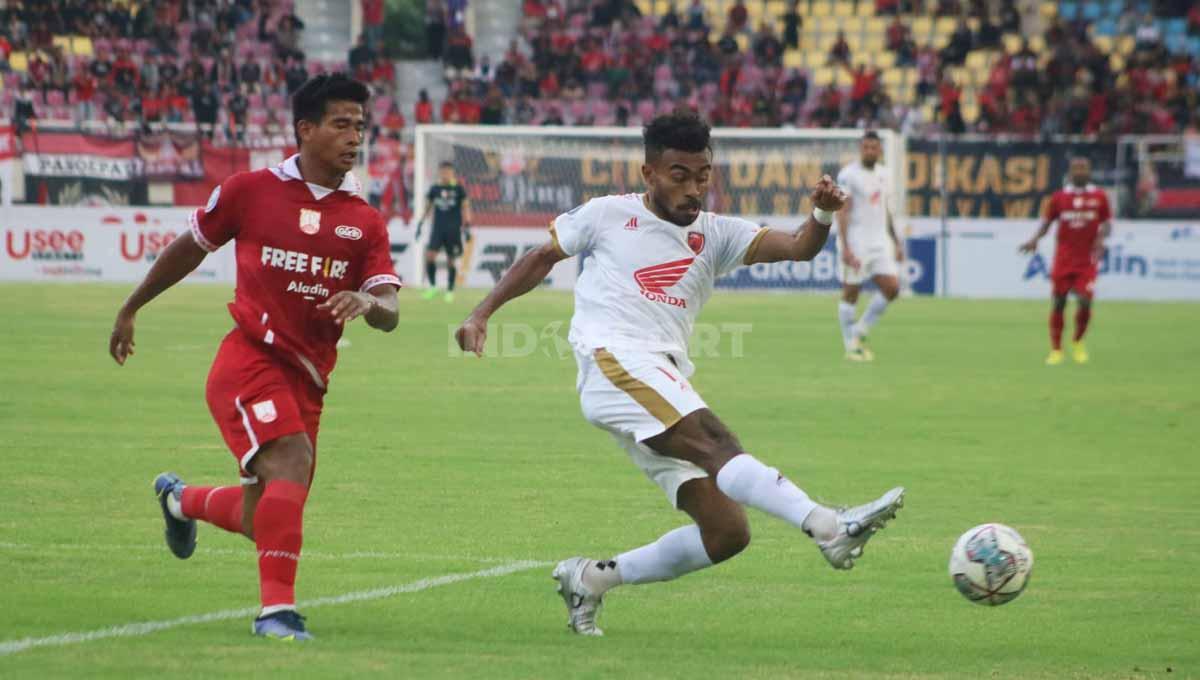 Bek PSM Makassar, Yance Sayuri menghalau bola yang hendak direbut Irfan Jauhari. Foto: Nofik Lukman Hakim/INDOSPORT - INDOSPORT