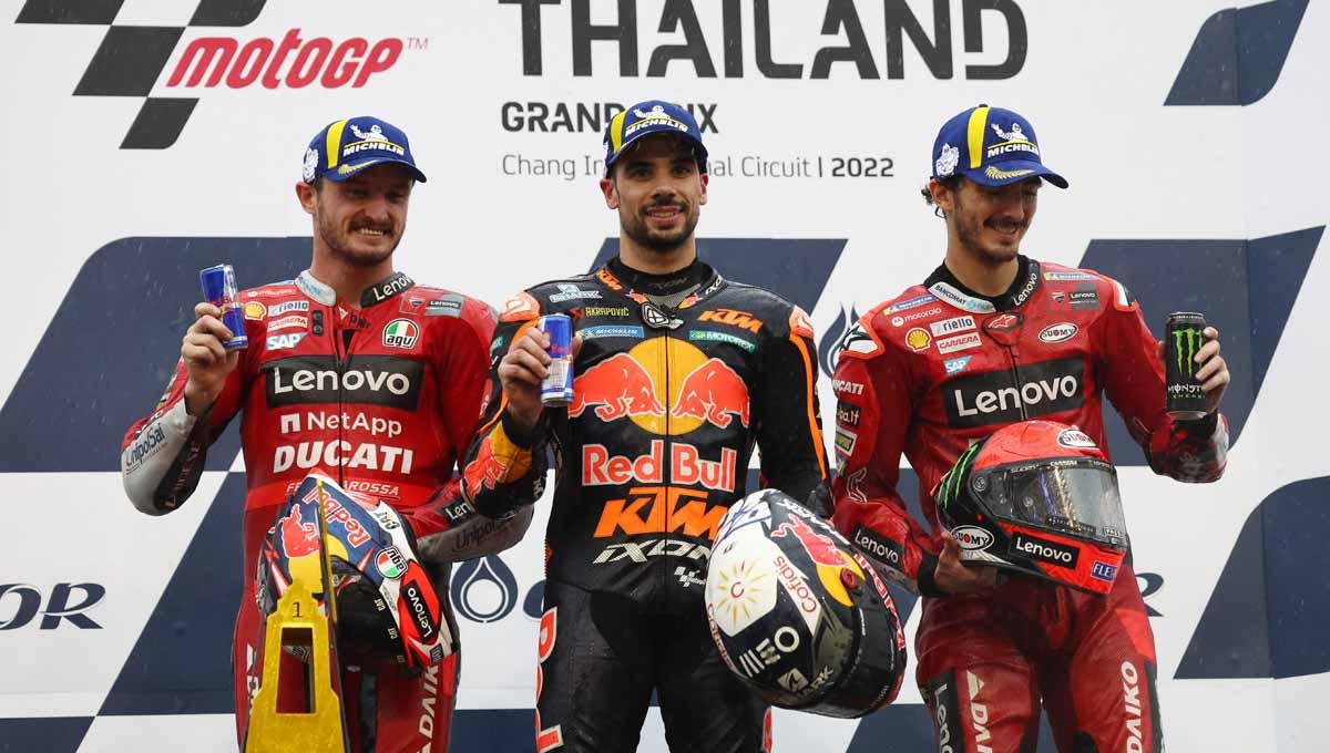 Pembalap Red Bull Miguel Oliveira di podium bersama Jack Miller dan Francesco Bagnaia di Sirkuit Internasional Chang, Buriram, Thailand, Minggu (02/10/22). Foto: REUTERS/Athit Perawongmetha