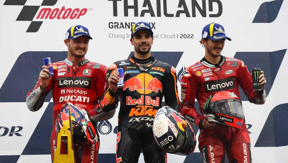 Pembalap Red Bull Miguel Oliveira di podium bersama Jack Miller dan Francesco Bagnaia di Sirkuit Internasional Chang, Buriram, Thailand, Minggu (02/10/22). Foto: REUTERS/Athit Perawongmetha - INDOSPORT