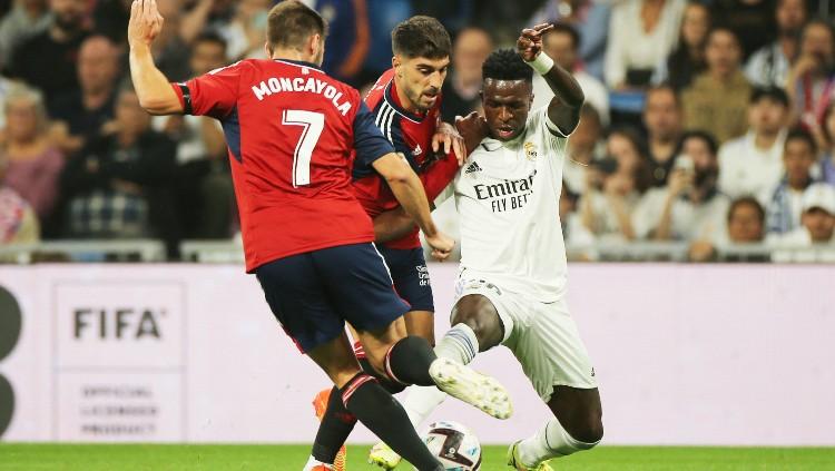 Vinicius Jr dikepung dua pemain di laga Real Madrid vs Osasuna (03/10/22). (Foto: REUTERS/Isabel Infantes) - INDOSPORT