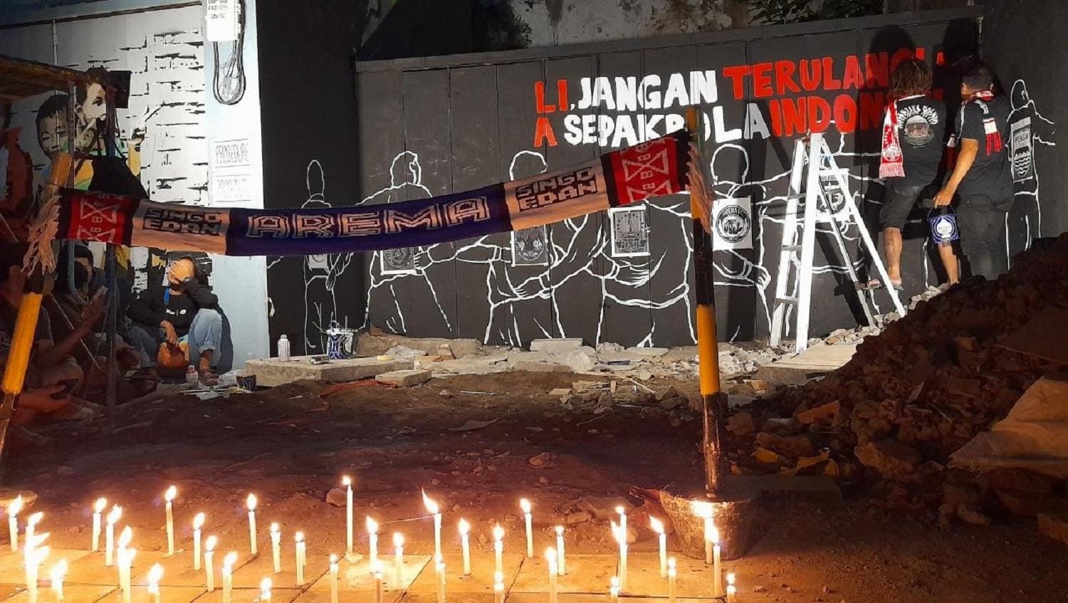 Mural solidaritas Tragedi Kanjuruhan menunjukkan suporter Persis Solo merangkul suporter PSIM Yogyakarta dan Arema FC. Foto: Nofik Lukman Hakim - INDOSPORT