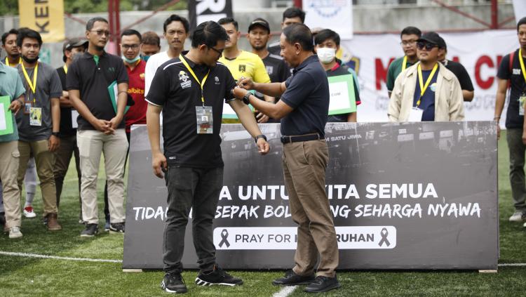 Menpora, Zainudin Amali saat memakaikan pita hitam kepada ketua pantia, Abdul Azis sebagai bentuk duka tragedi Kanjuruhan saat membuka perhelatan Media Cup 2022 di Triboon Mini Soccer, Kamis (06/10/22).