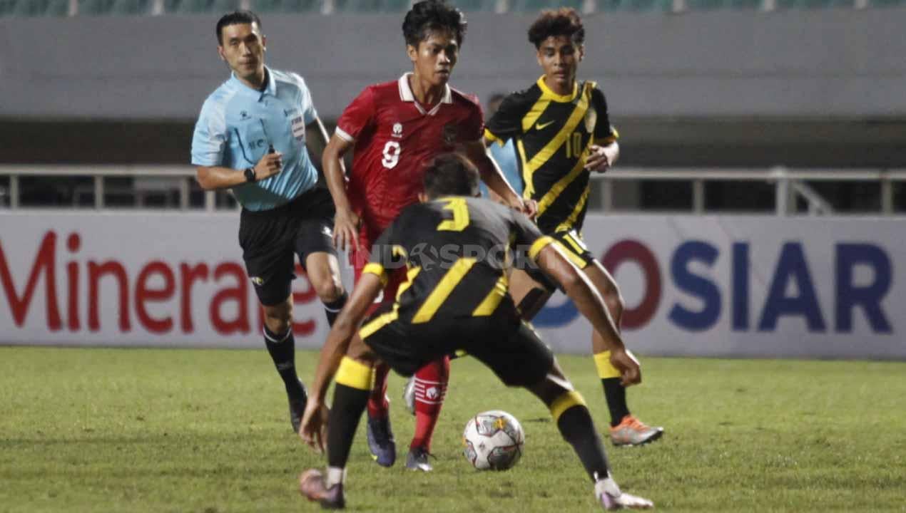 Pemain Timnas Indonesia U-17, Muhammad Kafiatur rizky berusaha melewati pemain Malaysia pada Kualifikasi Piala Asia U-17 grup B di Stadion Pakansari, Cibinong, Kabupaten Bogor, Jumat (09/10/22).