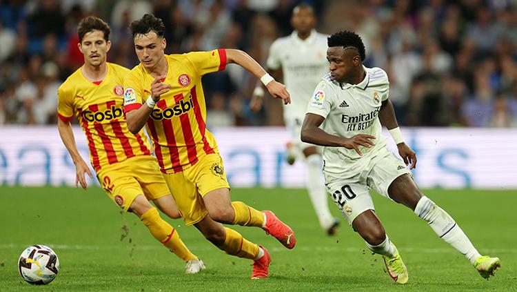 Penyerang Real Madrid, Vinicius Junior berebut bola dengan pemain Girona di Liga Spanyol.