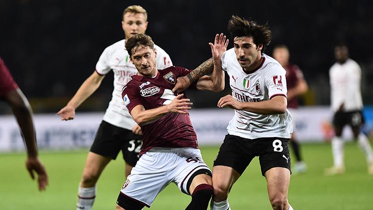 Perebutan bola antara pemain Torino dengan pemain AC Milan di Liga Italia. - INDOSPORT