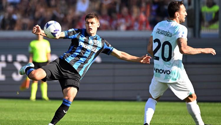 Hakan Calhanoglu (kanan) mencoba menghadang sepakan Mario Pasalic (13/11/22). (Foto: REUTERS/Alberto Lingria)