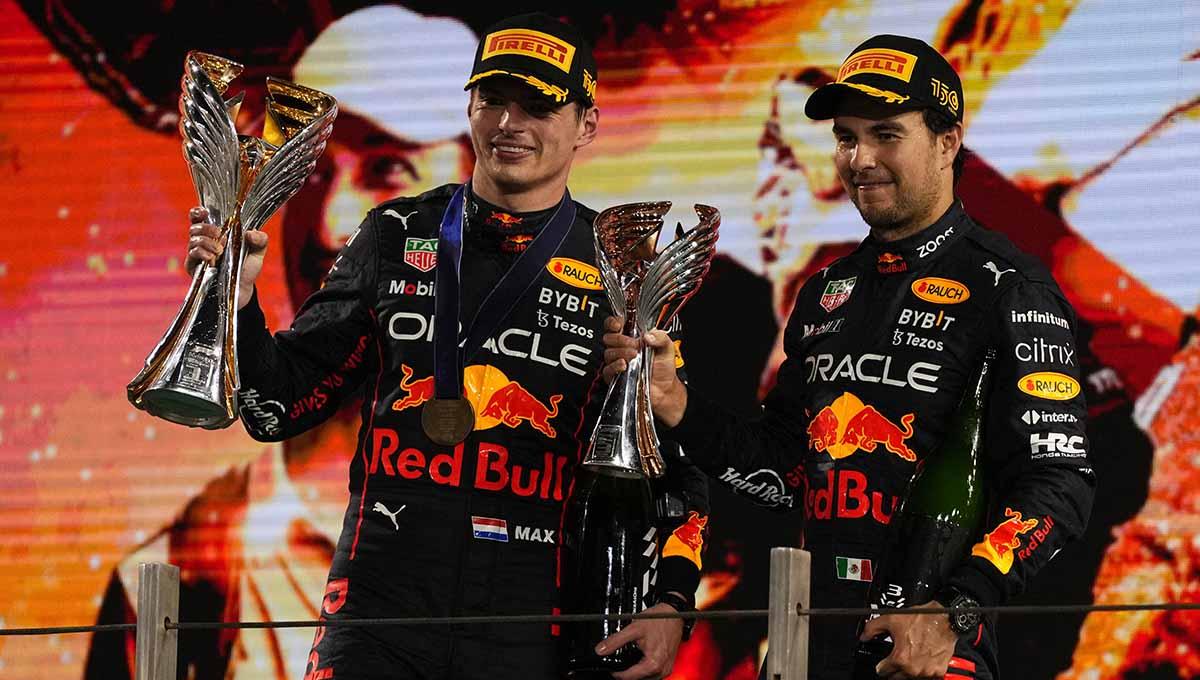 Max Verstappen dan Sergio Perez dari Red Bull angkat tropi di Grand Prix Abu Dhabi. (Foto: REUTERS/Aleksandra Szmigiel)