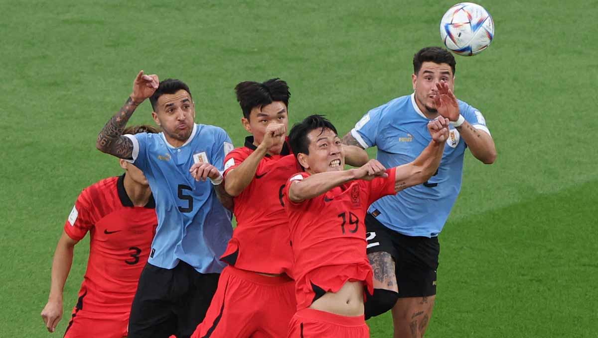 Duel udara pemain Korea Selatan Kim Young-gwon dan Hwang In-beom dengan pemain Uruguay Matias Vecino dan Jose Maria Gimenez grup H Piala Dunia Qatar 2022. (Foto: REUTERS/Molly Darlington) - INDOSPORT