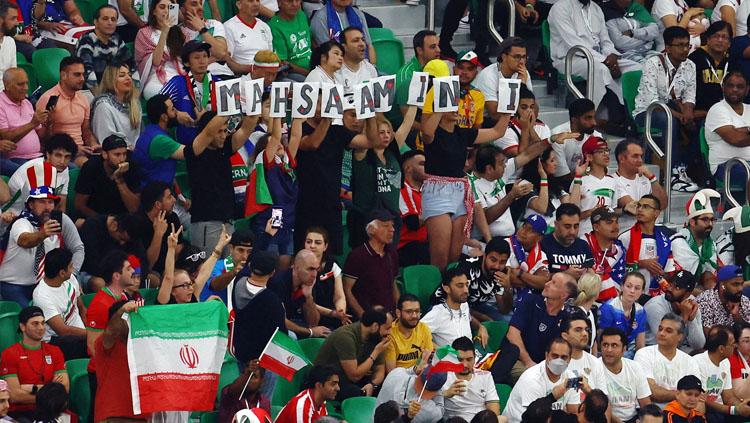 Fans Iran membentangkan nama Mahsa Amini sebagai bentuk protes dalam laga akhir Grup B Piala Dunia 2022 saat melawan Amerika Serikat (Foto: REUTERS/Molly Darlington). Copyright: REUTERS/Molly Darlington