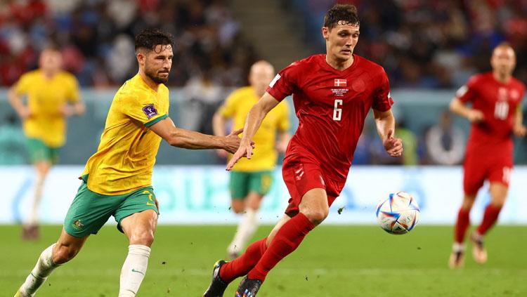 Laju pemain Austrlia, Mathew Leckie dihadang oleh pemain Denmark, Andreas Christensen dalam pertandingan akhir Grup D Piala Dunia 2022 (Foto: REUTERS/Bernadett Szabo). Copyright: REUTERS/Bernadett Szabo