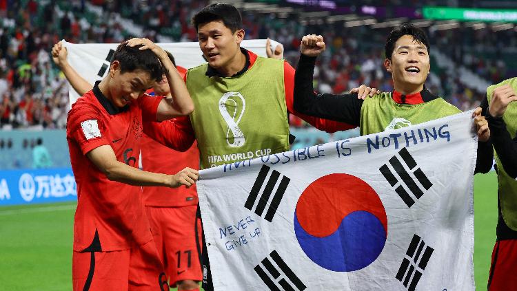 Hwang In-beom Korea Selatan dan Kim Min-jae merayakan dengan bendera setelah pertandingan saat Korea Selatan lolos ke babak 16 besar Piala Dunia 2022 REUTERS-Wolfgang Rattay - INDOSPORT