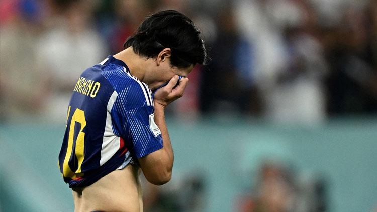Pemain bintang Timnas Jepang, Takumi Minamino menangis usai dikalahkan Kroasia di babak 16 besar Piala Dunia 2022 (Foto: REUTERS/Dylan Martinez). - INDOSPORT