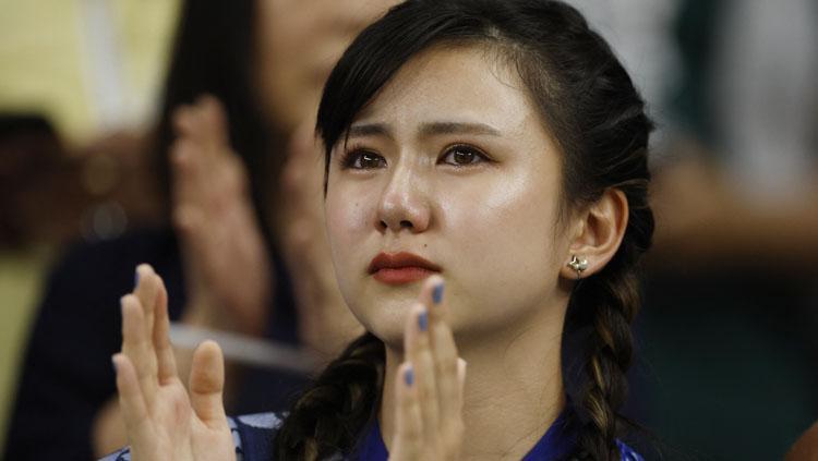Seorang fans Jepang tak kuasa menahan tangis saat negaranya kalah dari Kroasia di babak 16 besar Piala Dunia 2022 (Foto: REUTERS/John Sibley).REUTERS/John Sibley Copyright: REUTERS/John Sibley