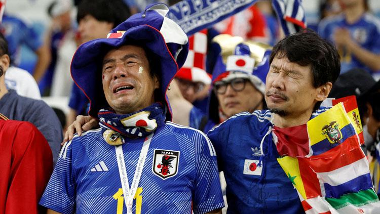 Ekspresi sedih dari fans Jepang saat negarnaya dipastikan pulang dari Piala Dunia 2022 usai dihempaskan oleh Kroasia (Foto: REUTERS/John Sibley). Copyright: REUTERS/John Sibley