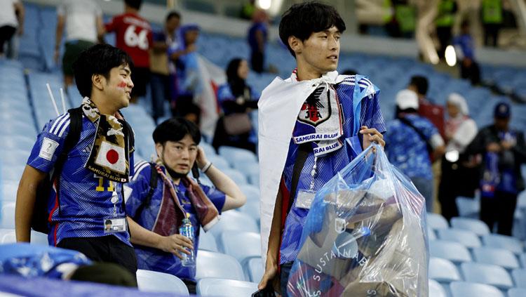 Aksi bersih-bersih dari Fans Jepang di tribun penonton Stadion Al Janoub usai pertandingan melawan Kroasia di babak 16 besar Piala Dunia  (Foto: REUTERS/John Sibley). Copyright: REUTERS/John Sibley