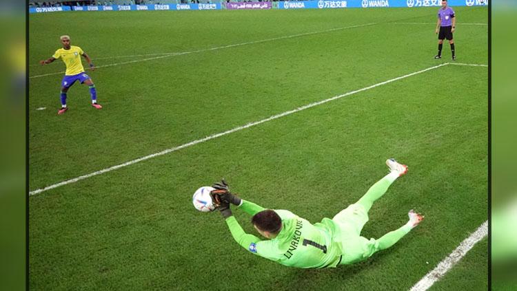 Kiper Timnas Kroasia, Dominik Livakovic saat menepis tendangan penalti dari pemain Brasil, Rodrygo di Babak Perempatfinal Piala Dunia 2022 (Foto: REUTERS/Matthew Childs).
