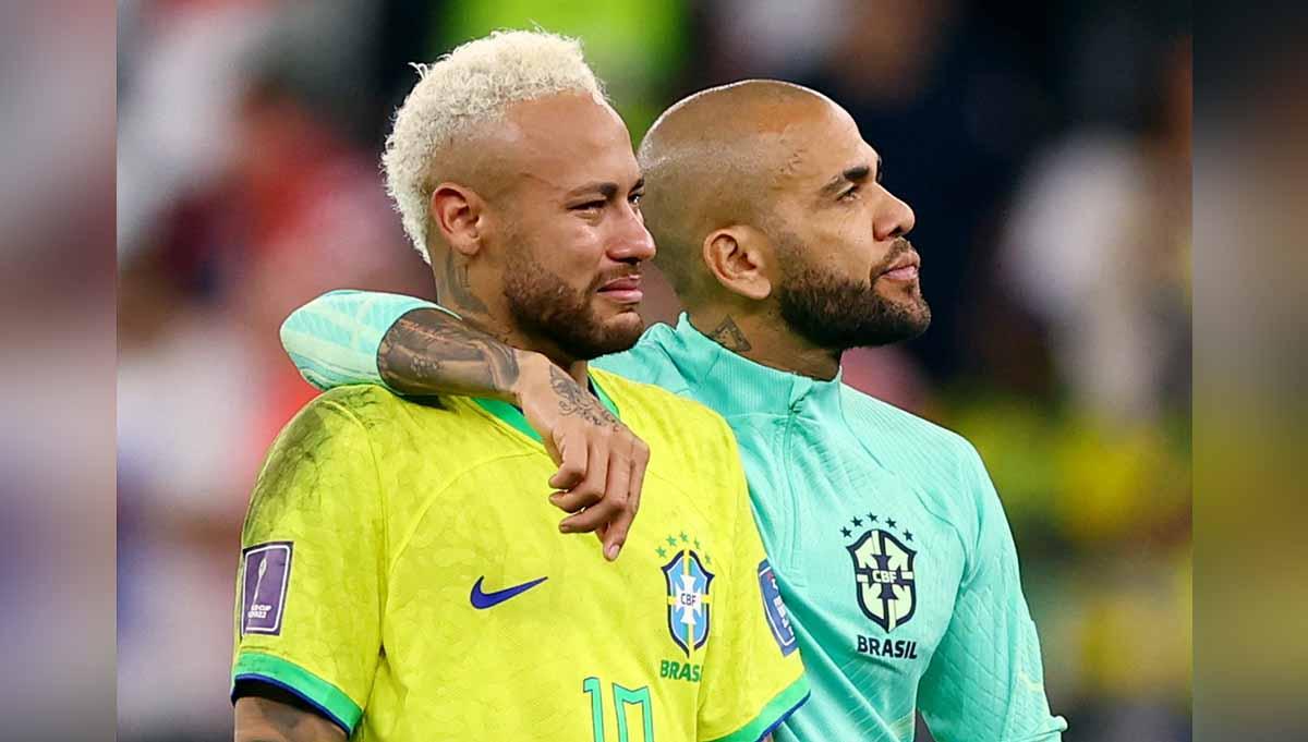 Dani Alves dan Neymar dari Brasil terlihat sedih setelah tersingkir dari Piala Dunia Qatar 2022. (Foto: REUTERS/Matthew Childs) - INDOSPORT