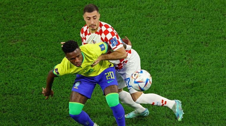 Bek kanan Kroasia, Josip Juranovic menjaga pergerakkan pemain Brasil, Viniciur Jr. dalam laga babak perempatfinal Piala Dunia 2022 (Foto: REUTERS/Lee Smith). - INDOSPORT