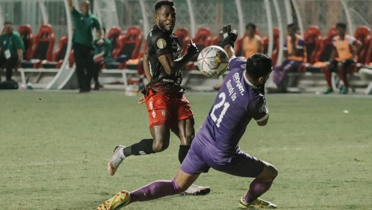 Privat Mbarga saat menyelesaikan peluang dalam laga melawan Madura United. Foto: Bali United
