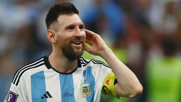 Pemain megabintang sekaligus kapten Timnas Argentina, Lionel Messi tersenyum lebar usai membawa timnya ke final Piala Dunia 2022 (Foto: REUTERS/Molly Darlington). - INDOSPORT