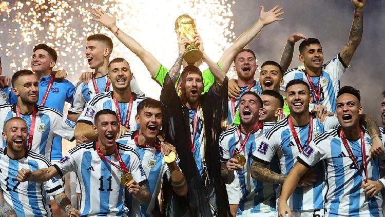 Lionel Messi dari Argentina mengangkat trofi Piala Dunia 2022 bersama rekan satu timnya REUTERS-Kai Pfaffenbach - INDOSPORT
