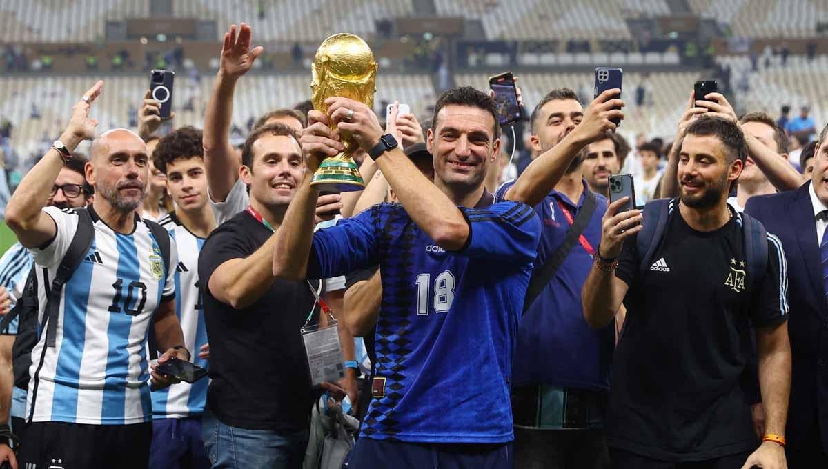 Lionel Scaloni berfoto dengan trofi Piala Dunia 2022 usai bawa Timnas Argentina juara. Foto: REUTERS/Hannah Mckay. - INDOSPORT