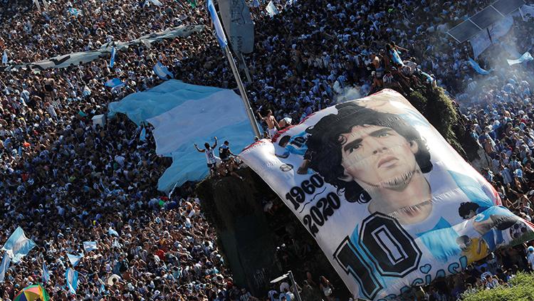 Pendukung timnas Argentina merayakan gelar Piala Dunia 2022 dengan membentangkan poster besar bergambar Diego Maradona.