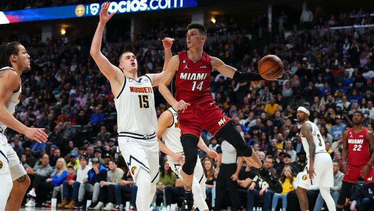 Aksi Tyler Herro (kanan) berduel dengan Nikola Jokic di laga NBA Denver Nuggets vs Miami Heat (31/12/22). (Foto: Reuters/Ron Chenoy-USA TODAY Sports) - INDOSPORT