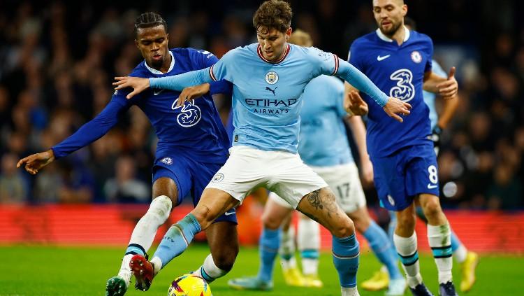 Carney Chukwuemeka (kiri) berduel dengan John Stones di laga Chelsea vs Manchester City (06/01/23). (Foto: Reuters/John Sibley)