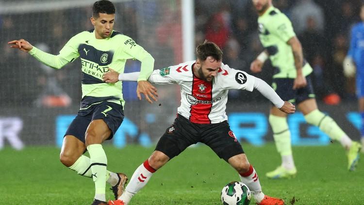 Joao Cancelo (kiri) berduel dengan Adam Armstrong (kanan) di laga Carabao Cup Southampton vs Manchester City (12/01/23). (Foto: REUTERS/David Klein)
