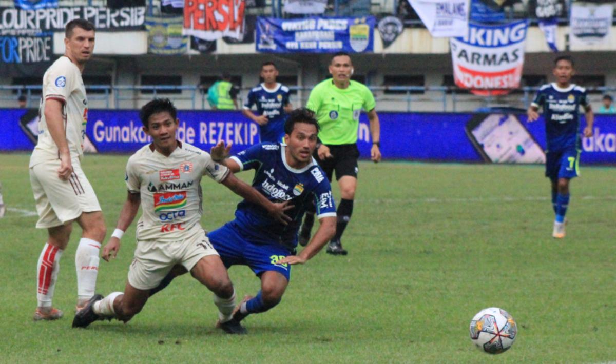 Firza Andika menjaga ketat Ezra Walian pada pertandingan tunda Liga 1 antara Persib Bandung melawan Persija Jakarta di Stadion GBLA, Rabu (11/01/2023).