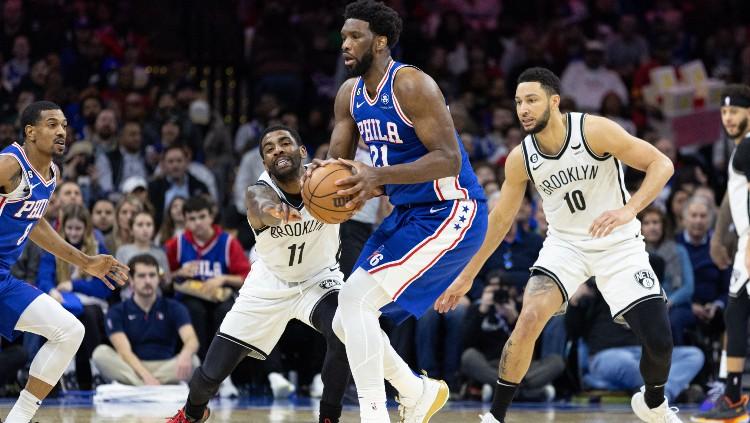 Joel Embiid (tengah) dikepung Kyrie Irving dan Ben Simmons di lanjutan NBA 2022-2023 Philadelphia 76ers vs Brooklyn Nets (26/01/23). (Foto: Reuters/Bill Streicher-USA TODAY Sports)