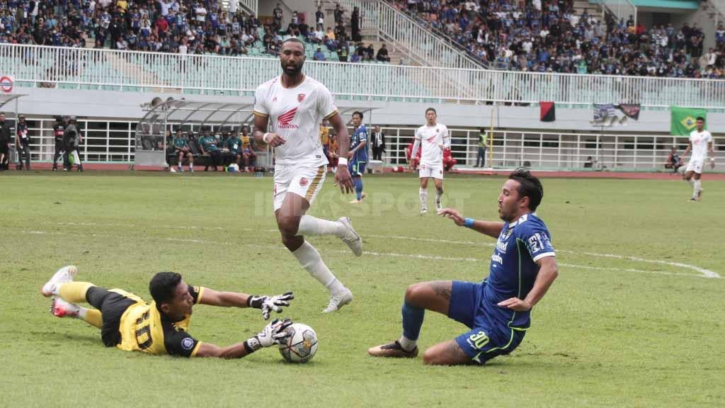 Peluang penyerang Persib Bandung Ezra Walian (kanan) saat berhadapan dengan penjaga gawang PSM Makassar dalam laga Liga 1 pekan ke-24 di Stadion Pakansari, Selasa (14/02/23).