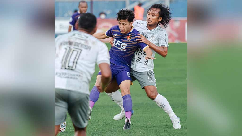 Gelandang Bali United Hariyono menjaga ketat pergerakan pemain Persik Kediri dalam laga Liga 1 pekan ke-24 di Stadion Brawijaya, Kediri, Selasa (14/02/23).