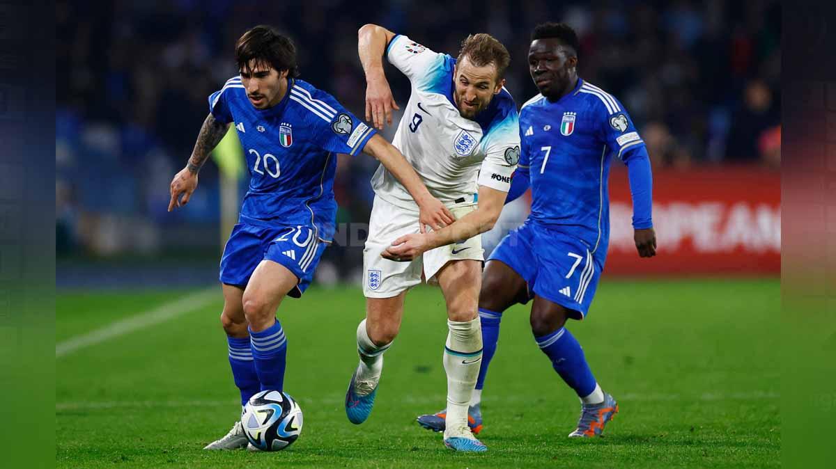 Pemain Inggris Harry Kane diapit oleh dua pemain Italia Sandro Tonali dan Wilfried Gnonto di Kualifikasi Euro 2024. (Foto: Reuters/Peter Cziborra) - INDOSPORT