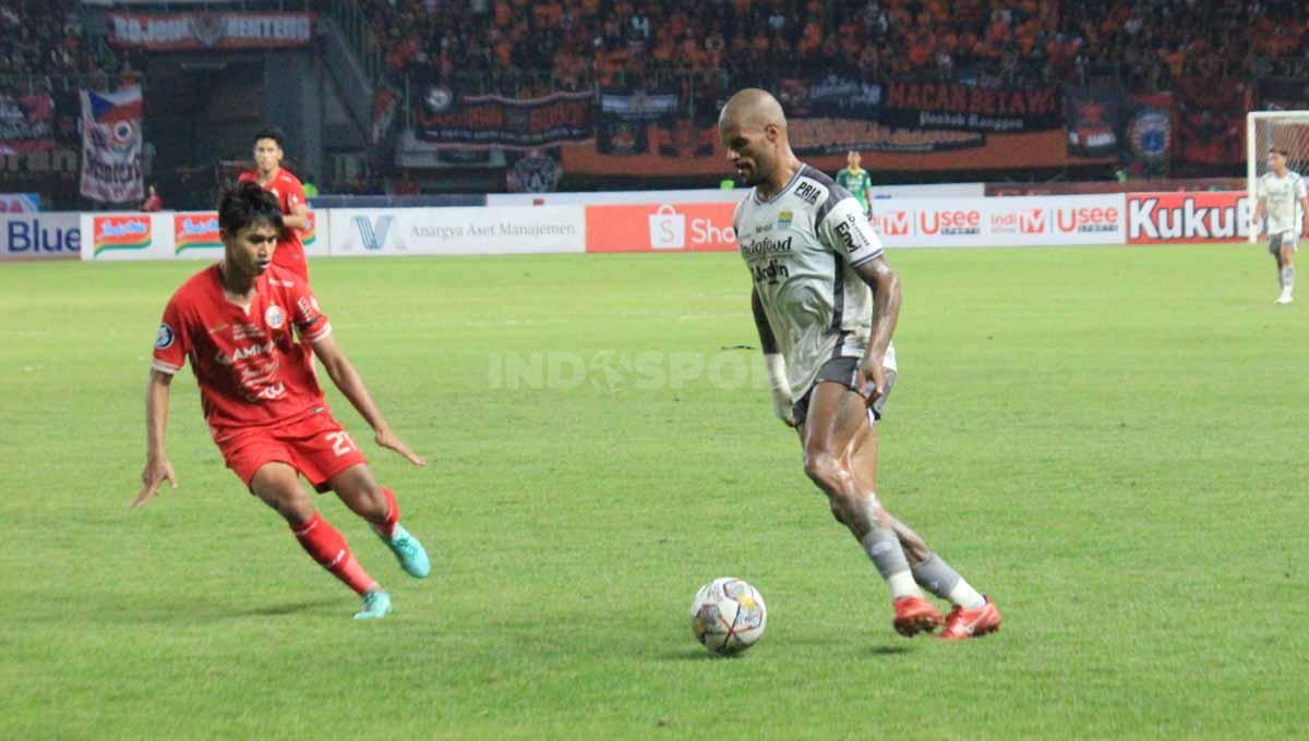 Striker Persib Bandung David da Silva mencoba melewati hadangan pemain Persija Jakarta pada laga tunda Liga 1 pekan ke-28 di Stadion Patriot Candrabhaga, Bekasi, Jumat (31/03/23).
