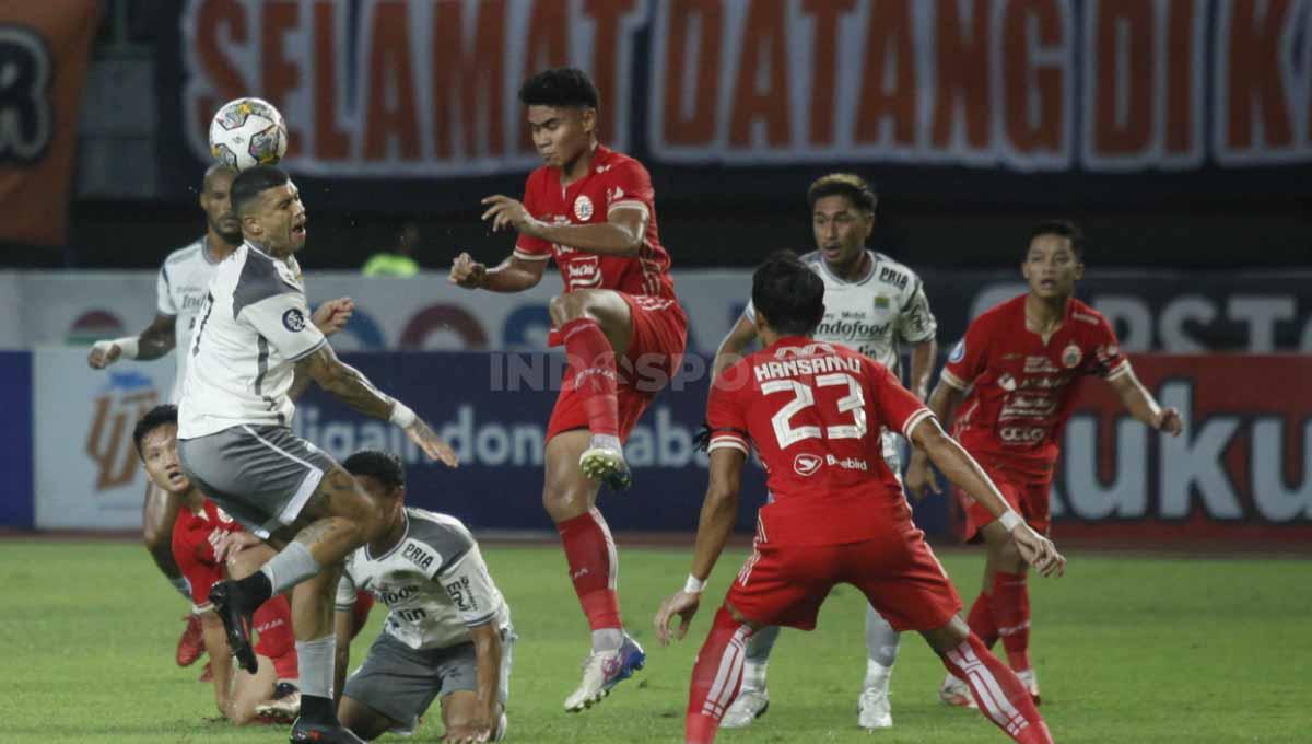 Striker Persib Bandung Ciro Alves (kiri) dilanggar oleh bek muda Persija Jakarta Muhammad Ferarri pada laga tunda Liga 1 pekan ke-28 di Stadion Patriot Candrabhaga, Bekasi, Jumat (31/03/23).