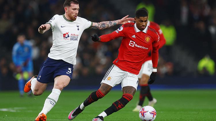 Penyerang Manchester United, Marcus Rashford, saat melindungi bola dari gangguan pemain Tottenham di Liga Inggris.