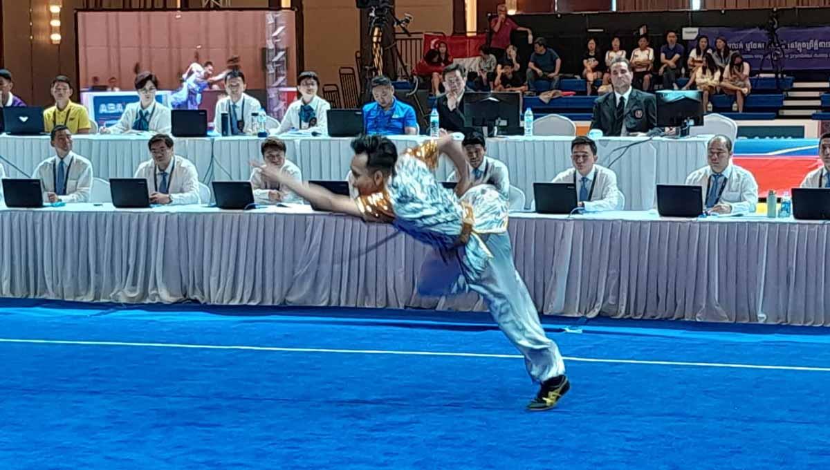 Atlet Taolu Indonesia, Muhammad Daffa Golden Boy menyumbangkan medali emas pertama dari nomor gabungan Jiangshu-Qiangshu Putra bagi Kontingen Merah Putih dari cabang olahraga wushu SEA Games 2023 Kamboja. (Foto: NOC Indonesia) - INDOSPORT