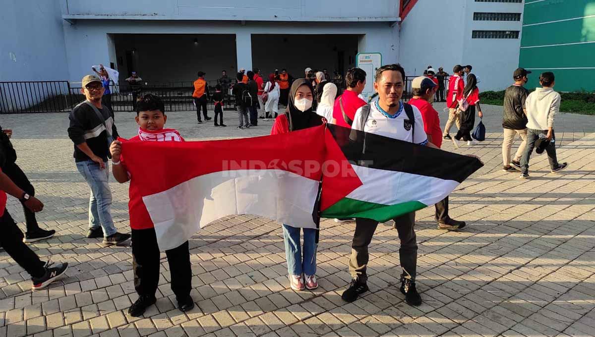 Andi iswoyo (baju putih) membawa bendera Palestina sebagai bentuk solidaritas. (Foto: Fitra Herdian/INDOSPORT)