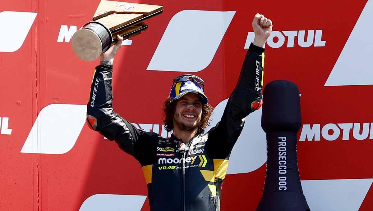 Marco Bezzecchi dari Mooney VR46 Racing Team merayakan dengan trofi di podium setelah finis kedua dalam balapan MotoGP, TT Circuit Assen, Belanda, Minggu (25/06/23). (Foto: REUTERS/Piroschka Van De Wouw)