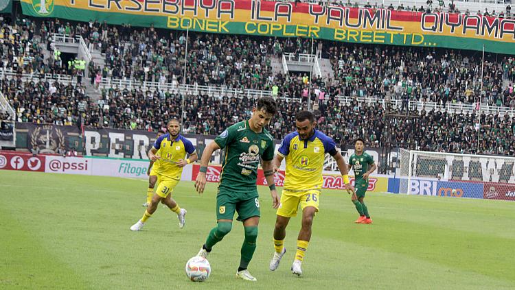 Pemain Persebaya Surabaya, Bruno Moreira (kiri) dijaga ketat pemain Barito Putera, Rizky Pora pada pertandingan Liga 1 pekan kedua di stadion GBT, Sabtu (08/07/23).
