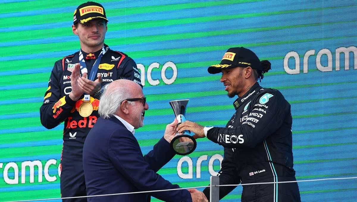Pembalap Mercedes Lewis Hamilton menerima trofi tempat ketiga di podium setelah balapan F1 GP Inggris di Sirkuit Silverstone, Inggris, Minggu (09/07/23). (Foto: REUTERS/Andrew Boyers)