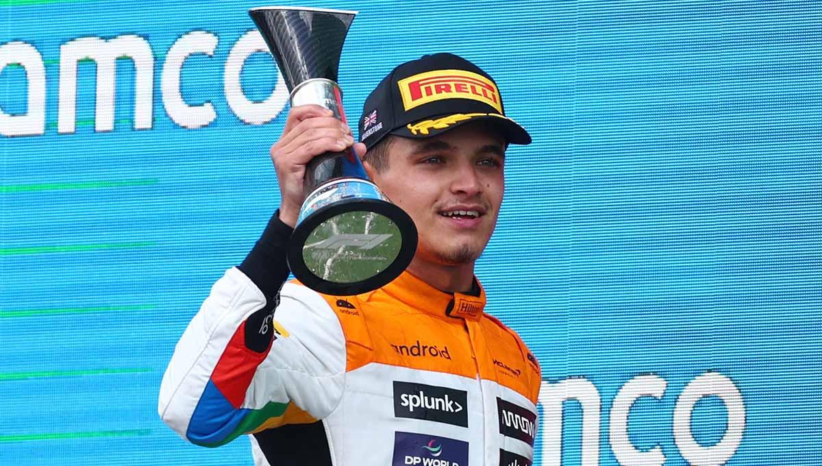 Pembalap McLaren Lando Norris merayakan dengan trofi di podium setelah menyelesaikan balapan di posisi kedua balapan F1 GP Inggris di Sirkuit Silverstone, Inggris, Minggu (09/07/23). (Foto: REUTERS/Andrew Boyers) - INDOSPORT