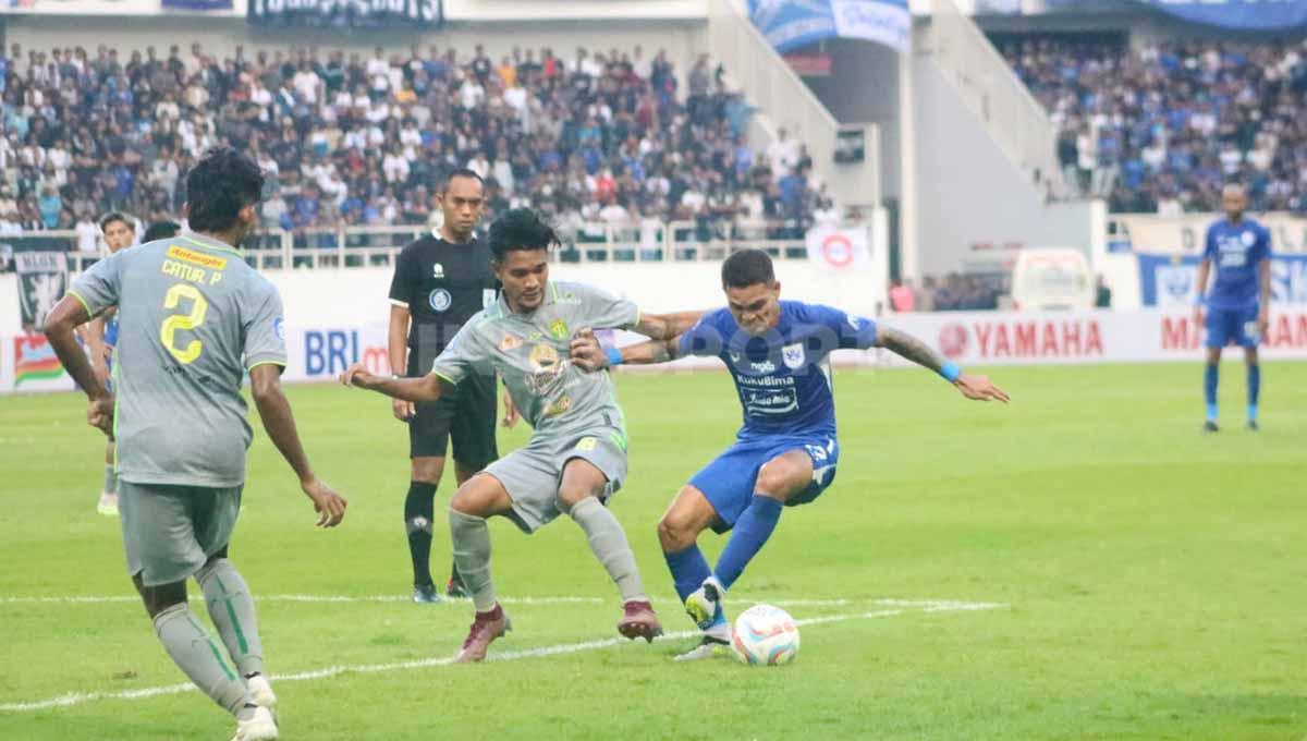 Pemain Persebaya berusaha menghalau bola dari kaki Pemain PSIS Semarang, Paulo Domingos Gali pada pertandingan pekan ketiga Liga 1 di Stadion Jatidiri (Semarang), Minggu (16/07/23).