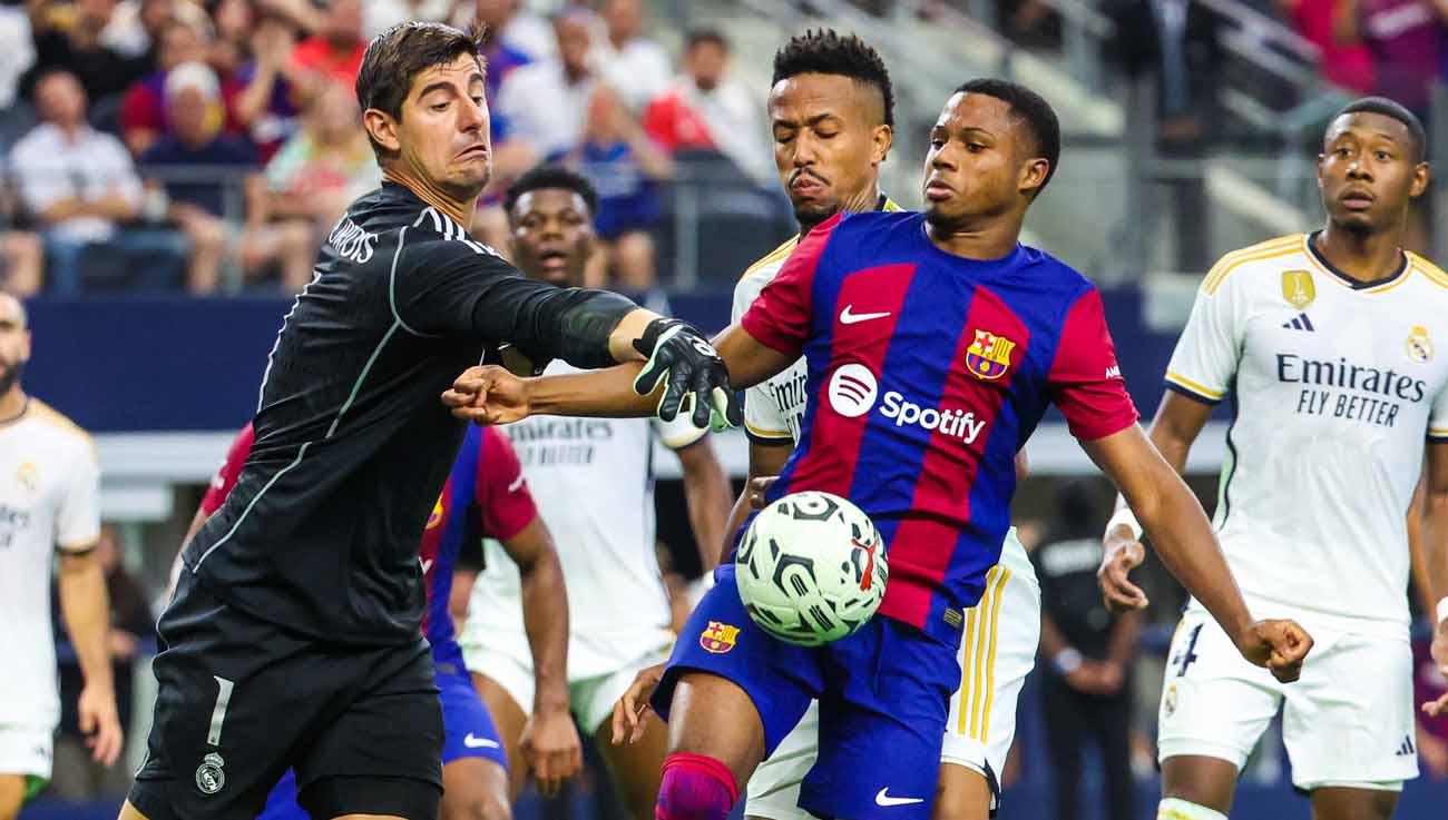 Penyerang Barcelona Ansu Fati mencoba mencetak gol melewati penjaga gawang Real Madrid Thibaut Courtois pada babak kedua di AT&T Stadium. (Foto: REUTERS/Kevin Jairaj) - INDOSPORT