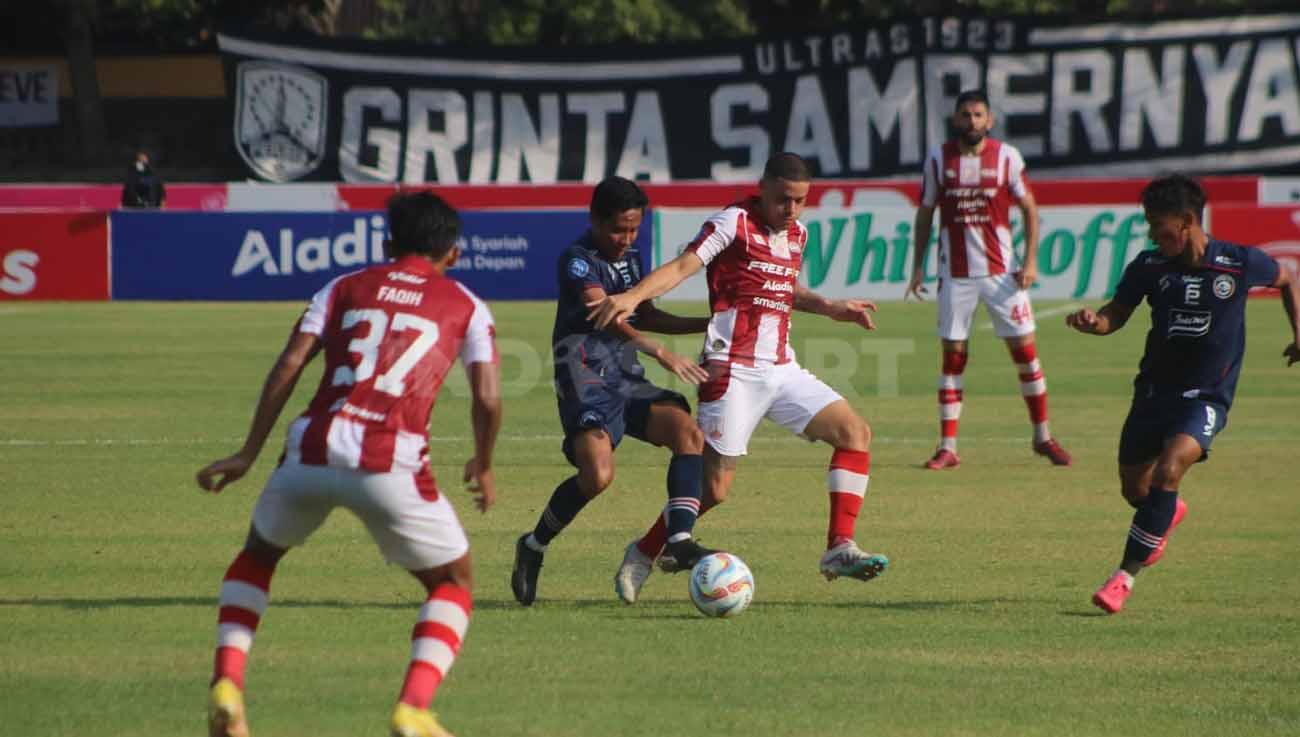 Pemain Arema Evan Dimas berebut bola dengan pemain Persis, Alexis Messidoro di laga Liga 1, Minggu (30/07/23). (Foto: Nofik Lukman Hakim/INDOSPORT)