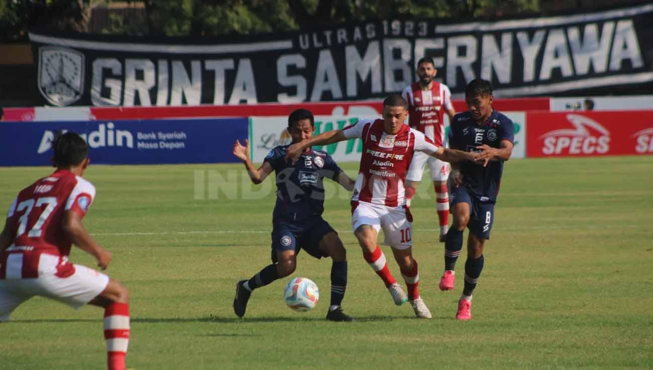 Pemain Arema Evan Dimas berebut bola dengan pemain Persis, Alexis Messidoro di laga Liga 1, Minggu (30/07/23). (Foto: Nofik Lukman Hakim/INDOSPORT)