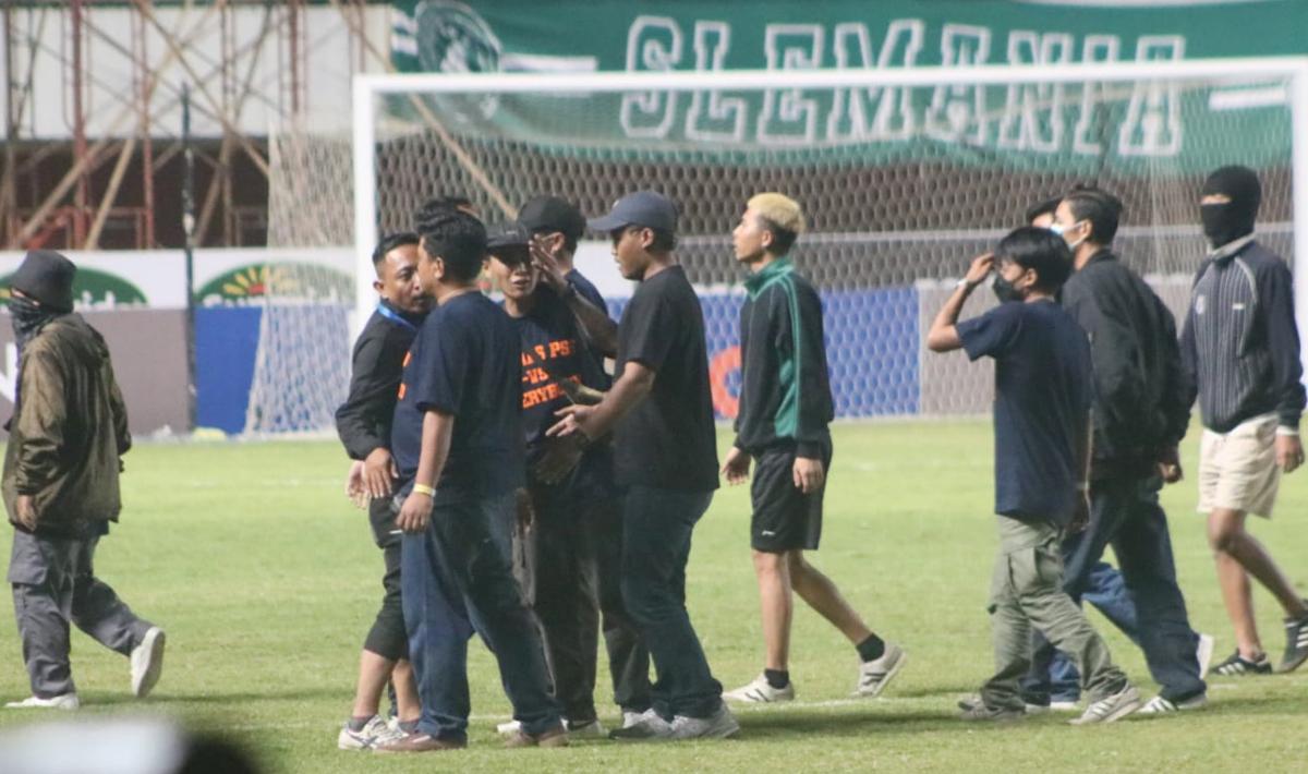 Suporter yang masuk ke lapangan dan mengejar wasit diamankan oleh petugas usai laga pekan keenam Liga 1 2023/2024 di stadion Maguwoharjo, Jumat (04/08/23).