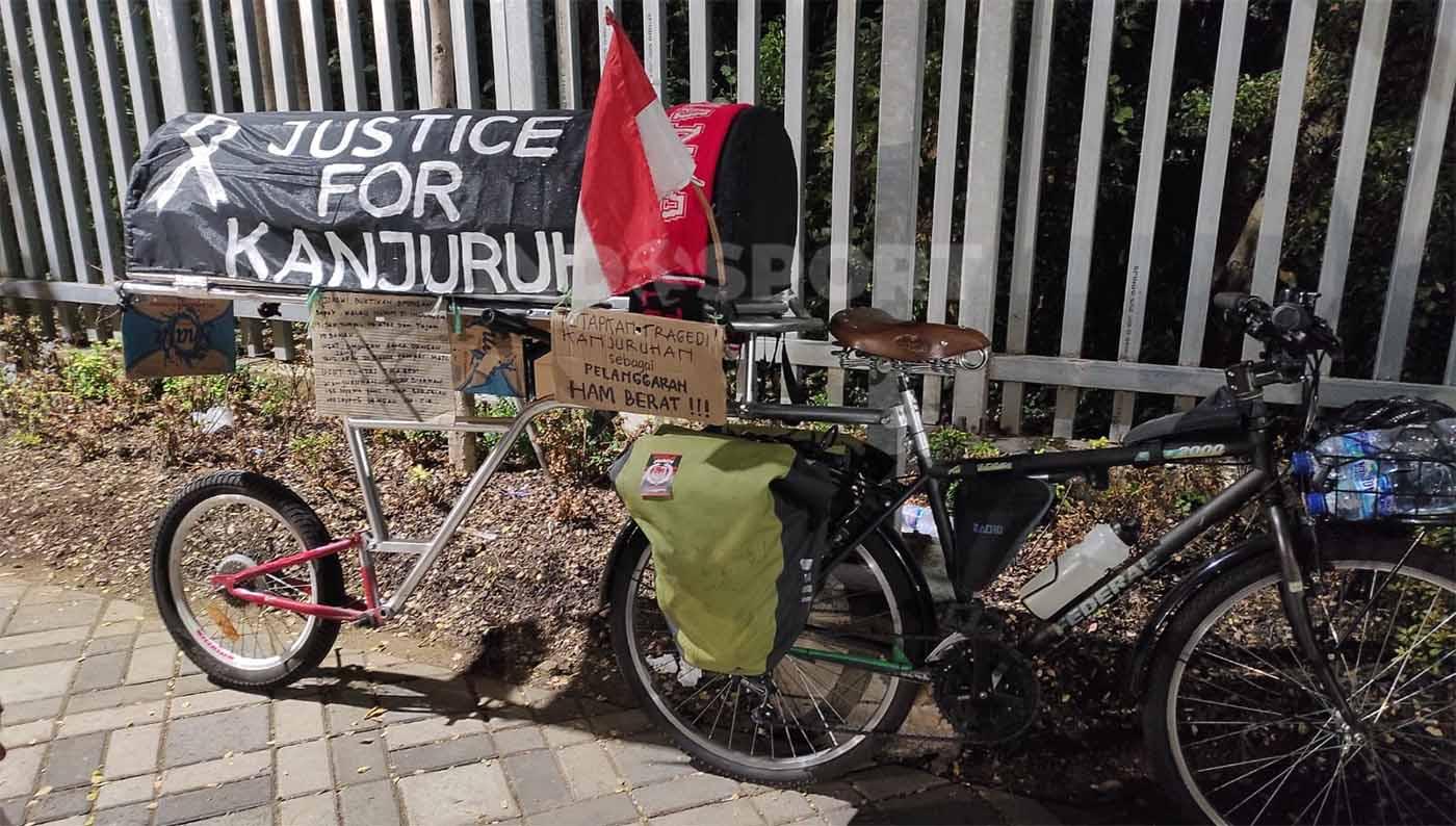 Miftahuddin Ramli atau Midun gowes dari Malang ke Jakarta dengan replika keranda bertuliskan Justice for Kanjuruhan. Foto: Fitra Herdian/INDOSPORT.